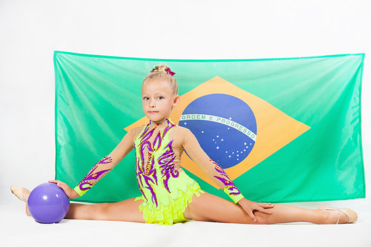 Girl doing rhythmic gymnastics element use ball. Brazilian flag
