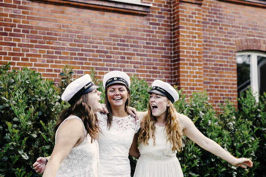 Excited female students screaming while celebrating at graduation party