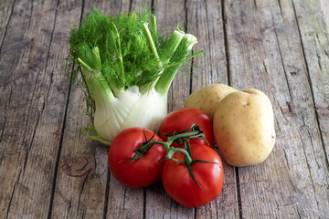 Fennel, tomatoes and potatoes on a wooden table