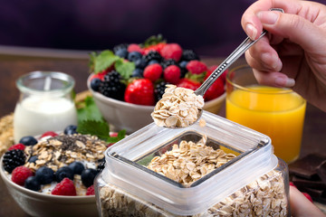 Spoon of oatmeal. Bowl with berries.