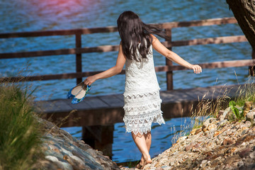 Girl in a white dress going down to the river