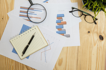 Office workplace with Magnifying glass on wood table,supplies an