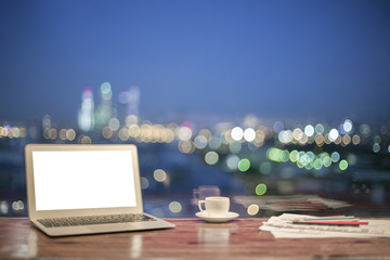 White laptop night city background