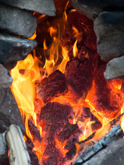 Burning wood closeup framed stones