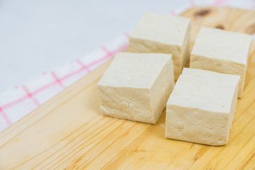 Block of fresh Tofu on wooden background (close-up shot)