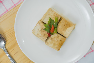 Block of Tofu and chopping board with chili and ginger