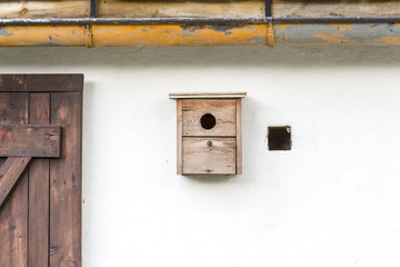 old simple nest box on a white wall
