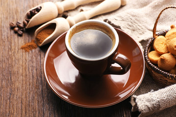 Cup of coffee with roasted and ground beans on table
