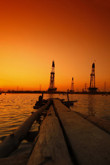 Obraz premium Sunset of oil drilling rig in the sea