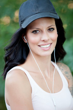 Brunette woman with headphones listening music walking in the fo