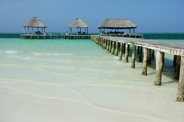 Pier and huts on a caribbean beach