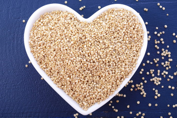 White grain quinoa on blue wood background.
