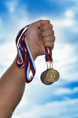 Fototapeta na wymiar The sportsman holding a gold medal