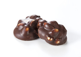 Chocolate pieces with nuts on a white background