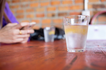 Water in a glass with ice placed on wooden table