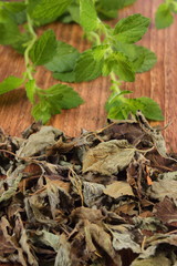 Heap of dried and fresh lemon balm on wooden table, herbalism