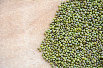 Green bean or mung bean seeds on a wooden floor.