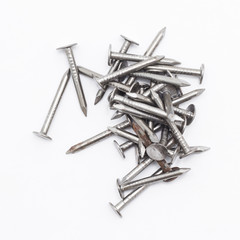 Closeup of a pile of rivets, nails isolated on white background
