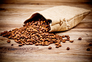 The sack of coffee beans on wooden background