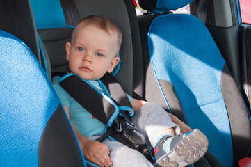 Baby in car seat for safety, looking outside