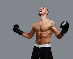 Tattooed fighter isolated on a grey background.