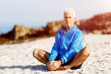 Man in sports wear sitting at the beach