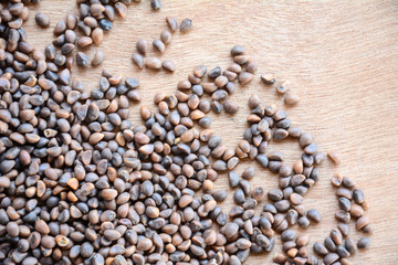 Background Morning Glory seeds on wooden floor.Organic Morning glory or kaladana (Ipomoea hederacea) seeds.Top view.