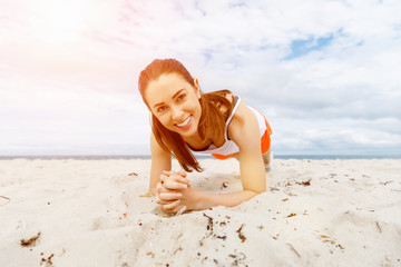 Fototapeta na wymiar Young woman training on beach outside