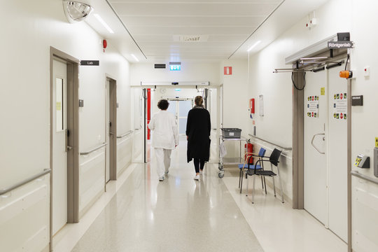 Rear view of women walking at hospital corridor