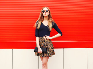 Fashion beautiful woman in leopard skirt sunglasses handbag clut