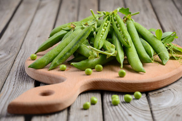 Fresh green peas on rustic wooden background, selective focus, copy space