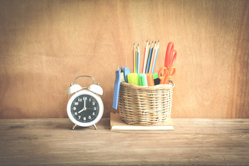 Time management concept:Alarm clock set at 8:00 and Writing in basket on book