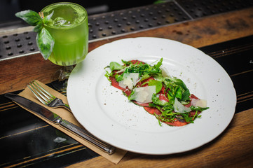 Beef carpaccio with parmesan cheese table setting