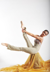 sports girl in a ballet hall in complex poze.balerina warming up, light tones picture. daylight falls on the blonde © georg01