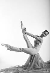 sports girl in a ballet hall in complex poze.balerina warming up, light tones picture. daylight falls on the blonde © georg01