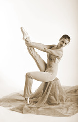 sports girl in a ballet hall in complex poze.balerina warming up, light tones picture. daylight falls on the blonde © georg01