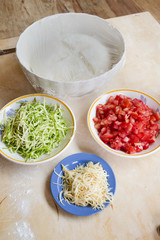 preparing pizza with dough and ingredients filling