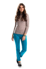 Woman in beige sweater smiling. Turquoise pants and footwear. Nice shoes for spring. Everyday spring outfit.