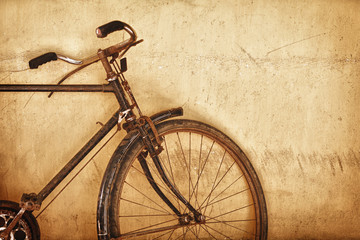 Old-fashioned rusty bicycle near the wall