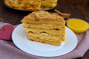 Honey cake on a dark wooden background. Cutting a piece. The top view.