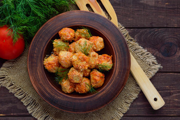 Meat balls with greens in a clay bowl. The top view