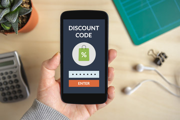 Hand holding smart phone with discount code concept on screen. All screen content is designed by me
