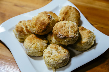 Homemade scones on white plate on wooden table