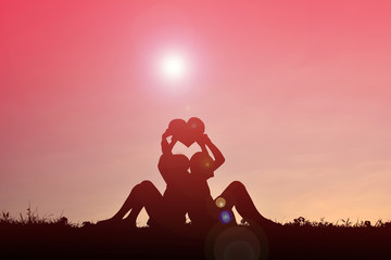 Silhouette children holding heart shape on sunset .Concept of love