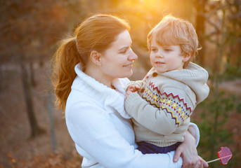 Mother and little son in park or forest, outdoors. 