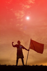 Silhouette boy holding flag at sunset. Concept success