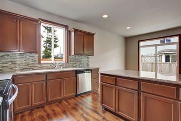 Modern kitchen room interior in an empty house. Furnished with dark brown cabinets.