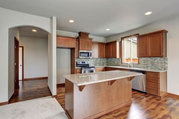 Bright kitchen room with stainless steel appliances and kitchen island.