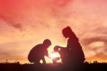 Silhouette mother and son at sunset