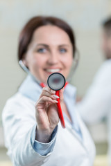 Portrait of woman doctor at hospital corridor, looking at camera.